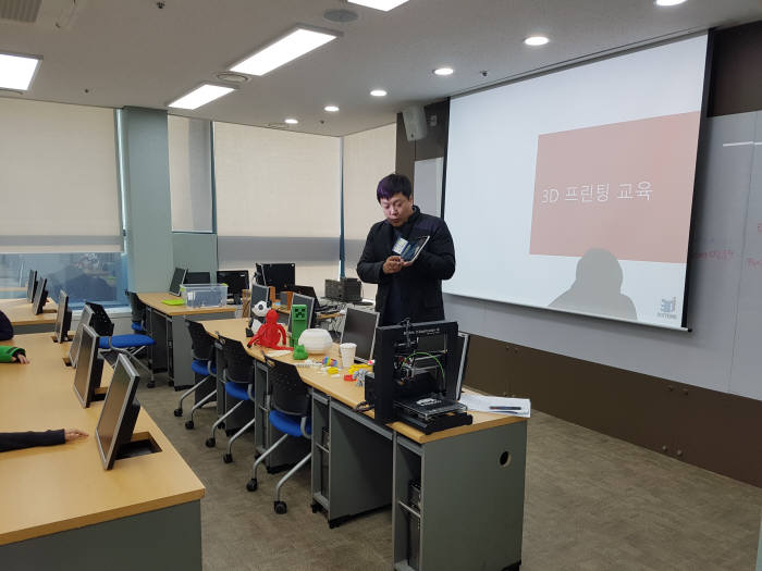 3D 프린팅 교육 강사가 학생들에게 3D프린팅으로 만든 작품을 소개하고 있다.