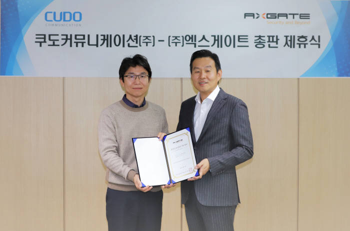 사진 왼쪽부터 엑스게이트 김태화 부사장. 김용식 쿠도커뮤니케이션 대표(오른쪽)와 김태화 엑스게이트 부사장이 총판 계약을 체결하고 기념촬영을 했다.