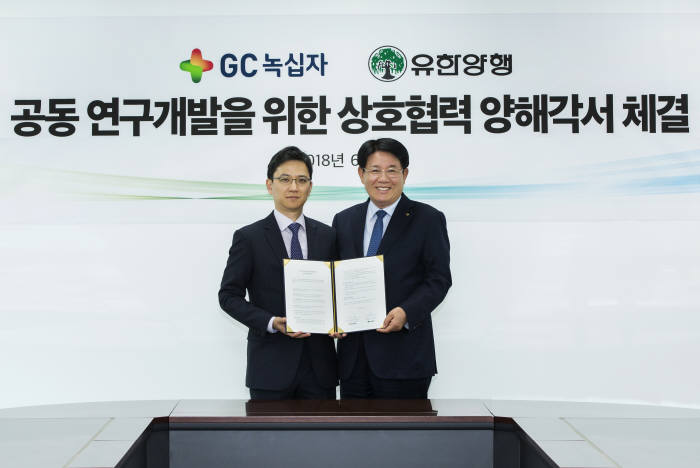 허은철 GC녹십자 사장(왼쪽)과 이정희 유한양행 사장이 18일 경기도 용인의 유한양행 중앙연구소에서 희귀의약품 연구개발 협력 내용의 MOU를 맺고 포즈를 취하고 있다.