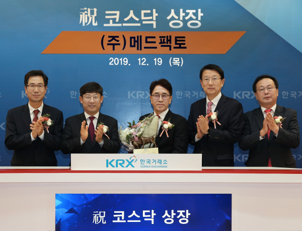 김성진 메드팩토 대표이사(가운데)가 지난해 12월 코스닥시장 신규상장식에서 기념촬영을 하고 있다.
