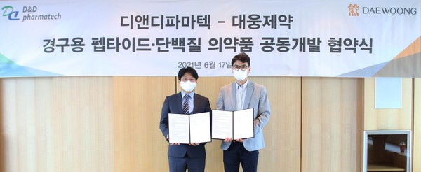 전승호 대웅제약 대표(오른쪽)와 임성묵 디앤디파마텍 대표가 협약서에 서명한 뒤 기념촬영을 하고 있다.