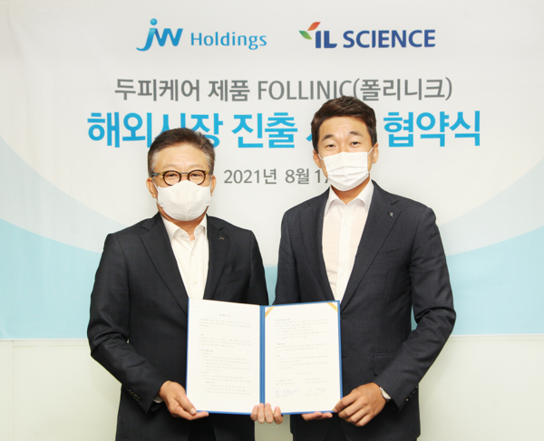JW홀딩스 한성권 대표(좌), 아이엘사이언스 송성근 대표(우)가 협약서에 서명한 뒤, 기념촬영하고 있다. 사진/JW홀딩스